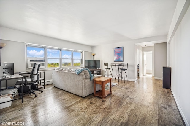 living room featuring wood finished floors, an office area, baseboards, a baseboard radiator, and cooling unit
