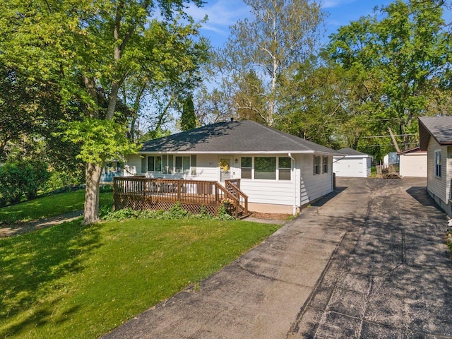view of front of property with a front lawn, a garage, and an outbuilding