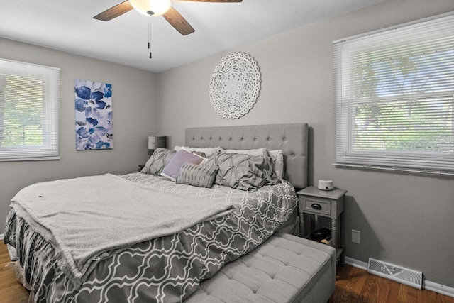 bedroom with multiple windows, wood finished floors, baseboards, and ceiling fan
