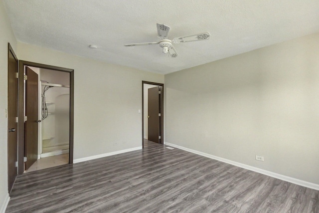 unfurnished bedroom with dark wood-type flooring, baseboards, a textured ceiling, ceiling fan, and a closet