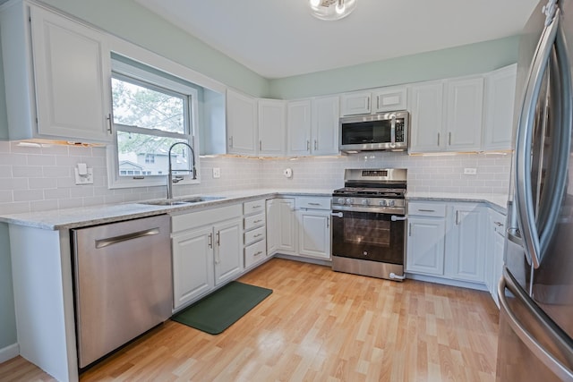 1706 Childs St, Wheaton, IL 60187 - kitchen with stainless steel appliances, a sink, light wood finished floors, and white cabinetry