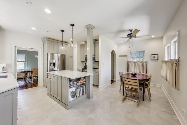 kitchen with stainless steel fridge, gray cabinets, arched walkways, ceiling fan, and recessed lighting