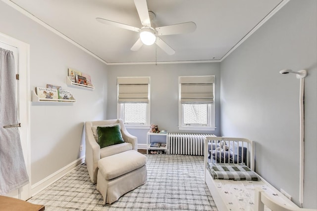 bedroom featuring radiator heating unit, ornamental molding, a nursery area, a ceiling fan, and carpet flooring
