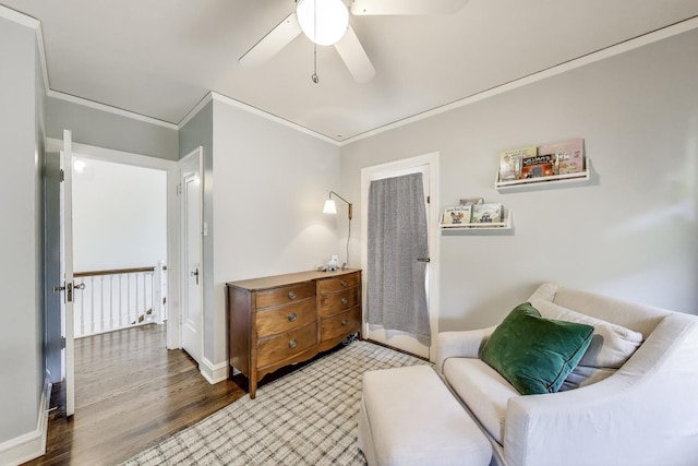 living area featuring crown molding, wood finished floors, a ceiling fan, and baseboards