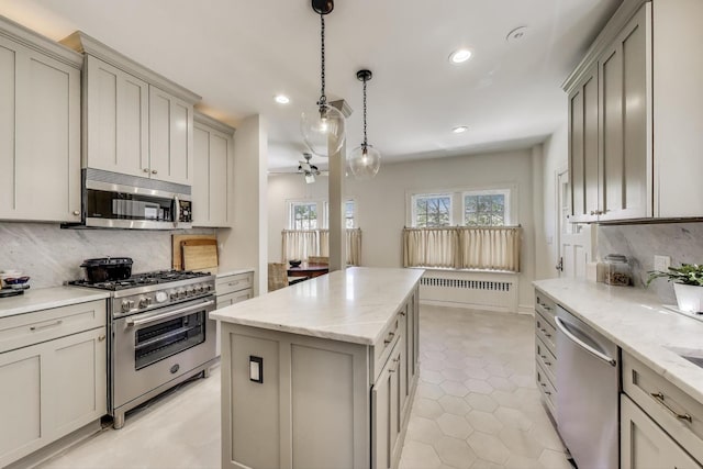 kitchen featuring appliances with stainless steel finishes, recessed lighting, tasteful backsplash, a center island, and pendant lighting