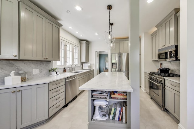 kitchen with stainless steel appliances, gray cabinetry, tasteful backsplash, a sink, and recessed lighting
