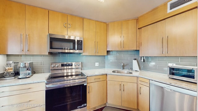 6033 N Sheridan Rd Unit 27B, Chicago, IL 60660 - kitchen featuring stainless steel appliances, a sink, light brown cabinets, decorative backsplash, and light stone countertops