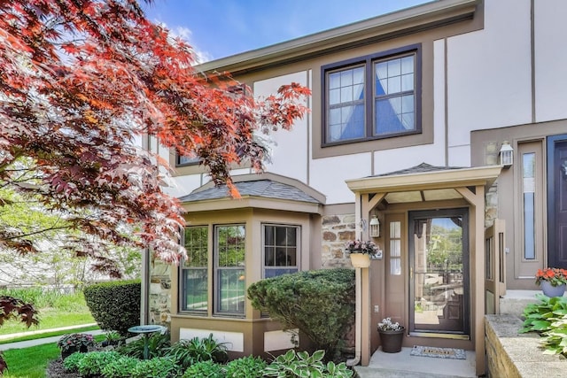 view of exterior entry with stucco siding and stone siding