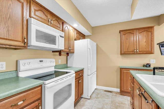 1109 Pomona Dr Unit 1109, Champaign, IL 61822 - kitchen featuring white appliances, brown cabinetry, light tile patterned floors, a textured ceiling, and light countertops