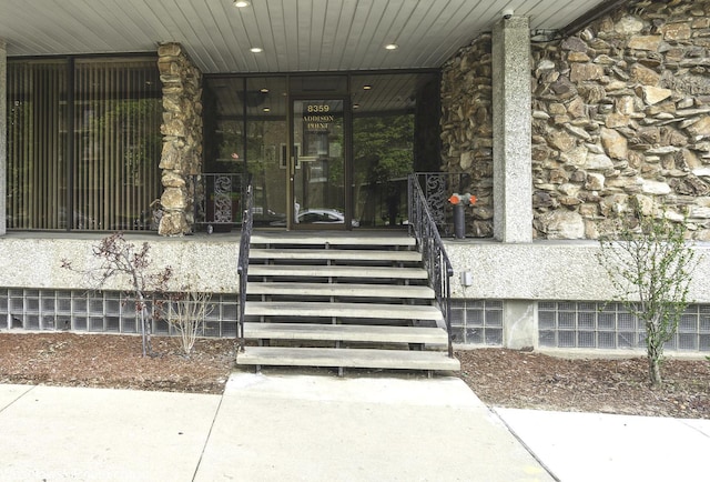 property entrance featuring stone siding and a porch