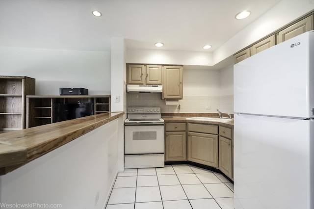 kitchen featuring white appliances, a sink, under cabinet range hood, backsplash, and recessed lighting
