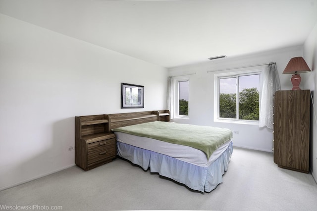 bedroom featuring light carpet and baseboards