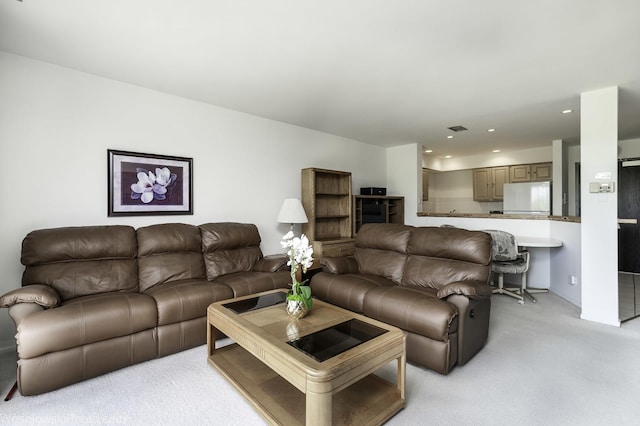 living area featuring light colored carpet and recessed lighting