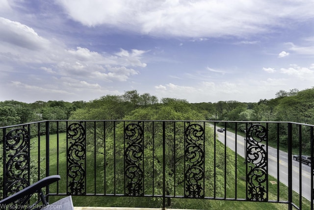 balcony featuring a wooded view