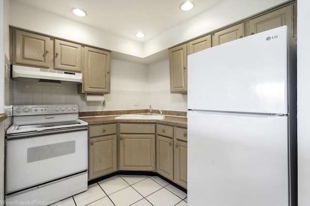kitchen with white appliances, under cabinet range hood, a sink, dark countertops, and light tile patterned floors