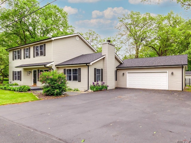 19 Eastwood Ave, Port Barrington, IL 60010 - view of front of house with asphalt driveway, a chimney, a shingled roof, and an attached garage