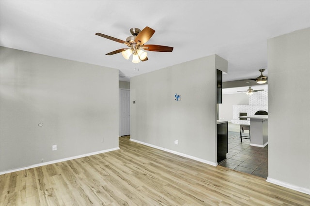 1903 Alton Dr, Champaign, IL 61821 - unfurnished room with a ceiling fan, wood finished floors, a brick fireplace, and baseboards