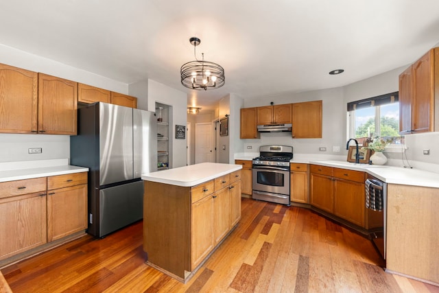 2990 Melbourne Ln, Lake In The Hills, IL 60156 - kitchen with appliances with stainless steel finishes, under cabinet range hood, a sink, wood finished floors, and a center island