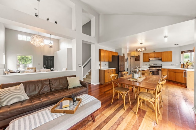 2990 Melbourne Ln, Lake In The Hills, IL 60156 - living area featuring high vaulted ceiling, stairs, a chandelier, and light wood finished floors