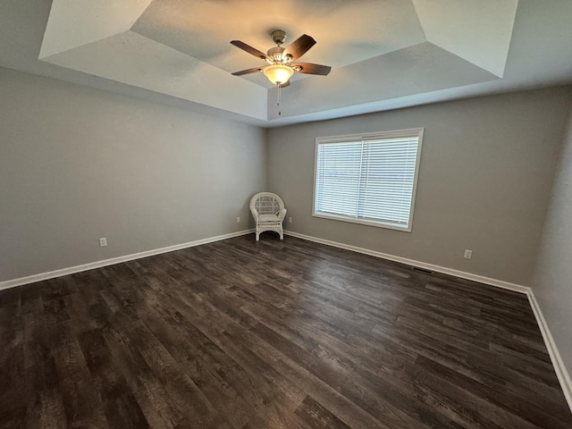 734 Keller Dr, Dixon, IL 61021 - spare room with a tray ceiling, dark wood-type flooring, baseboards, and ceiling fan