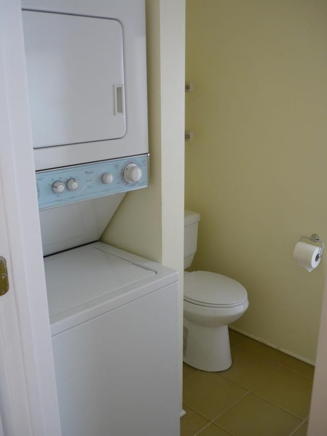 1926 W Grand Ave, Chicago, IL 60622 - bathroom with stacked washer / dryer, tile patterned flooring, toilet, and baseboards