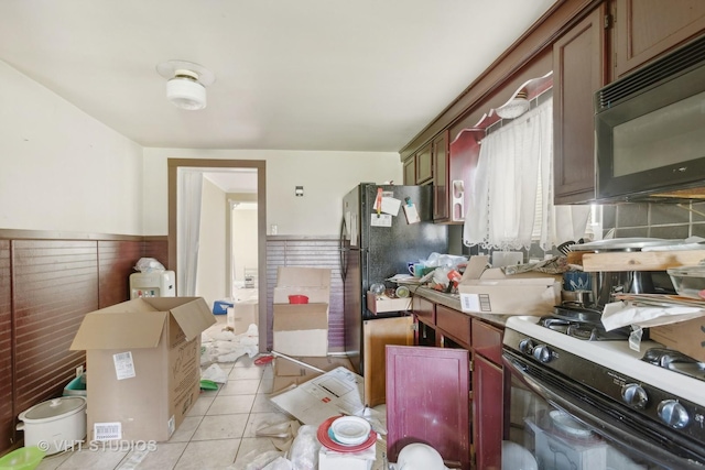 492 Freeland Ave, Calumet City, IL 60409 - kitchen featuring black appliances, light tile patterned flooring, light countertops, and a wainscoted wall