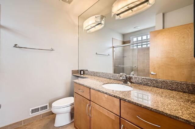 1405 N Orleans St Unit 5N, Chicago, IL 60610 - full bath with vanity, a stall shower, tile patterned floors, and an AC wall unit