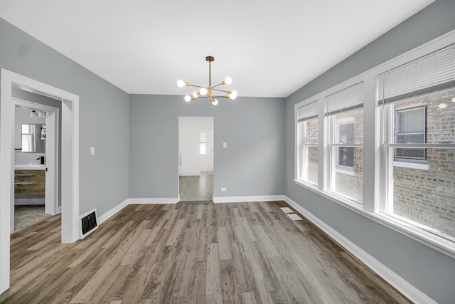 8623 S Wallace St, Chicago, IL 60620 - unfurnished dining area featuring a chandelier, wood finished floors, and baseboards