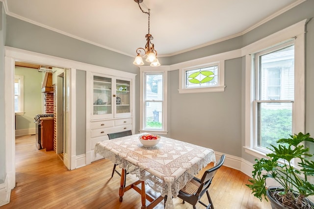 144 Hill Ave, Elgin, IL 60120 - dining area with healthy amount of natural light, light wood-type flooring, ornamental molding, and a chandelier