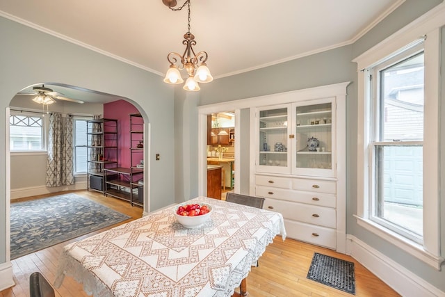 144 Hill Ave, Elgin, IL 60120 - dining area with arched walkways, light wood finished floors, a chandelier, ornamental molding, and a ceiling fan