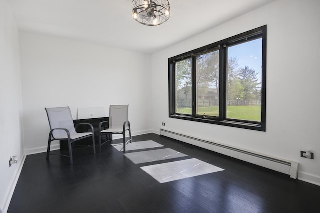 office space featuring a baseboard radiator, baseboards, wood finished floors, and a chandelier