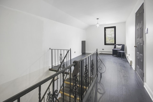 corridor with an upstairs landing, a baseboard radiator, dark wood-style flooring, lofted ceiling, and baseboards