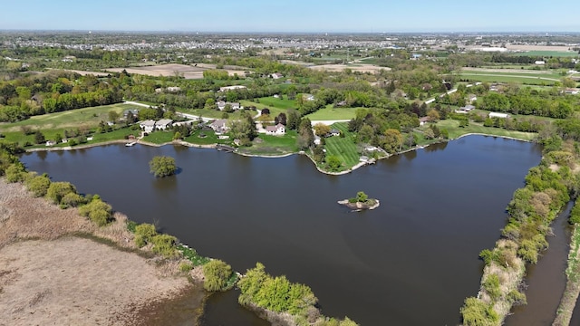 aerial view of property and surrounding area with a nearby body of water and a tree filled landscape