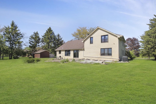 back of property featuring cooling unit, an outdoor structure, a lawn, and a patio area