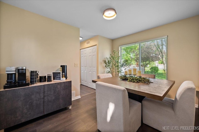 dining room featuring dark wood-type flooring and baseboards