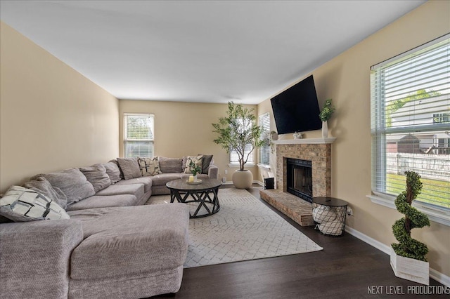 living area with a fireplace, wood finished floors, and baseboards