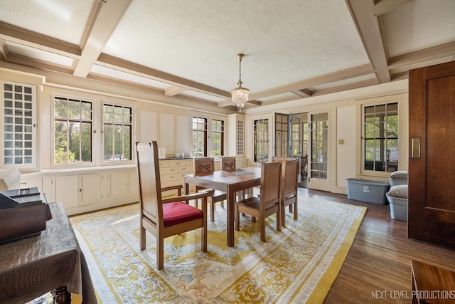 dining space featuring coffered ceiling, plenty of natural light, light wood-type flooring, and beamed ceiling