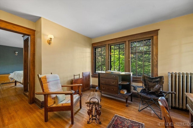 sitting room featuring radiator heating unit, wood finished floors, and baseboards