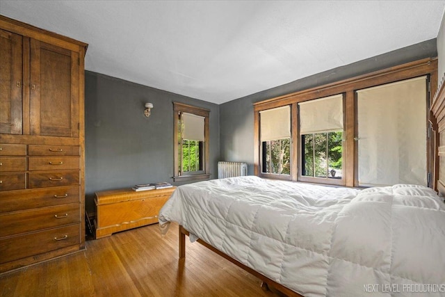 bedroom with radiator and light wood-type flooring
