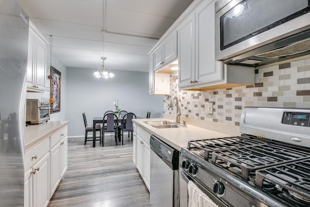5S040 Pebblewood Ln Unit W503, Naperville, IL 60563 - kitchen featuring appliances with stainless steel finishes, a sink, white cabinets, and a chandelier