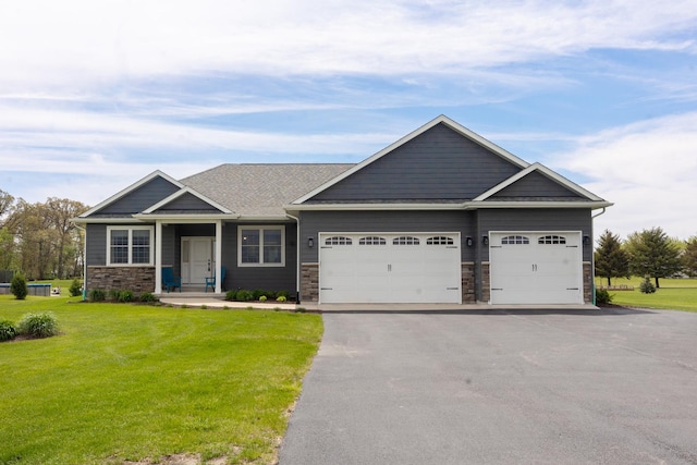 10499 E Shagbark Ln, Rochelle, IL 61068 - craftsman-style house with a garage, asphalt driveway, a front yard, and stone siding