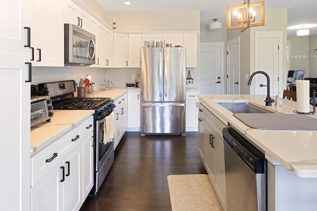 10499 E Shagbark Ln, Rochelle, IL 61068 - kitchen with appliances with stainless steel finishes, a sink, a chandelier, white cabinets, and a center island with sink