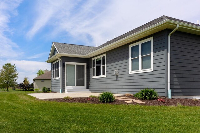 10499 E Shagbark Ln, Rochelle, IL 61068 - rear view of house with a patio area, a lawn, and a shingled roof