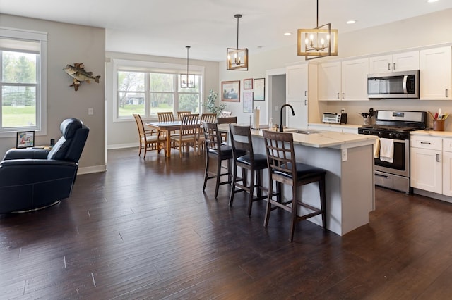 10499 E Shagbark Ln, Rochelle, IL 61068 - kitchen with stainless steel appliances, a sink, a chandelier, recessed lighting, and a breakfast bar area