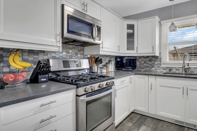 3019 Harris Dr, Joliet, IL 60431 - kitchen featuring appliances with stainless steel finishes, a sink, white cabinetry, and decorative backsplash