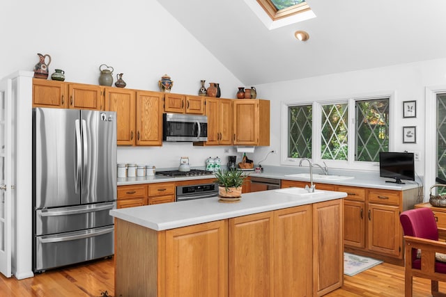 7N204 Eagle Ave, Medinah, IL 60157 - kitchen with appliances with stainless steel finishes, a skylight, light countertops, lofted ceiling, and a center island