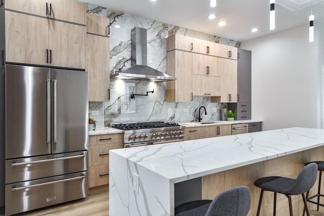 1832 N Kimball Ave, Chicago, IL 60647 - kitchen with high quality appliances, wall chimney exhaust hood, a kitchen bar, light stone countertops, and decorative backsplash