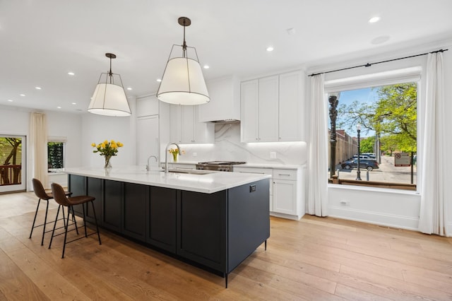 343 W Goethe St, Chicago, IL 60610 - kitchen featuring a sink, light countertops, white cabinetry, light wood-type flooring, and recessed lighting