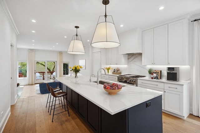 343 W Goethe St, Chicago, IL 60610 - kitchen featuring stainless steel gas range oven, white cabinetry, light wood-type flooring, recessed lighting, and crown molding