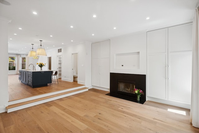 343 W Goethe St, Chicago, IL 60610 - living room featuring ornamental molding, light wood finished floors, a fireplace with flush hearth, recessed lighting, and baseboards